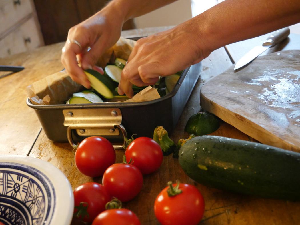 Preparing courgettes and tomatoes on a wooden table