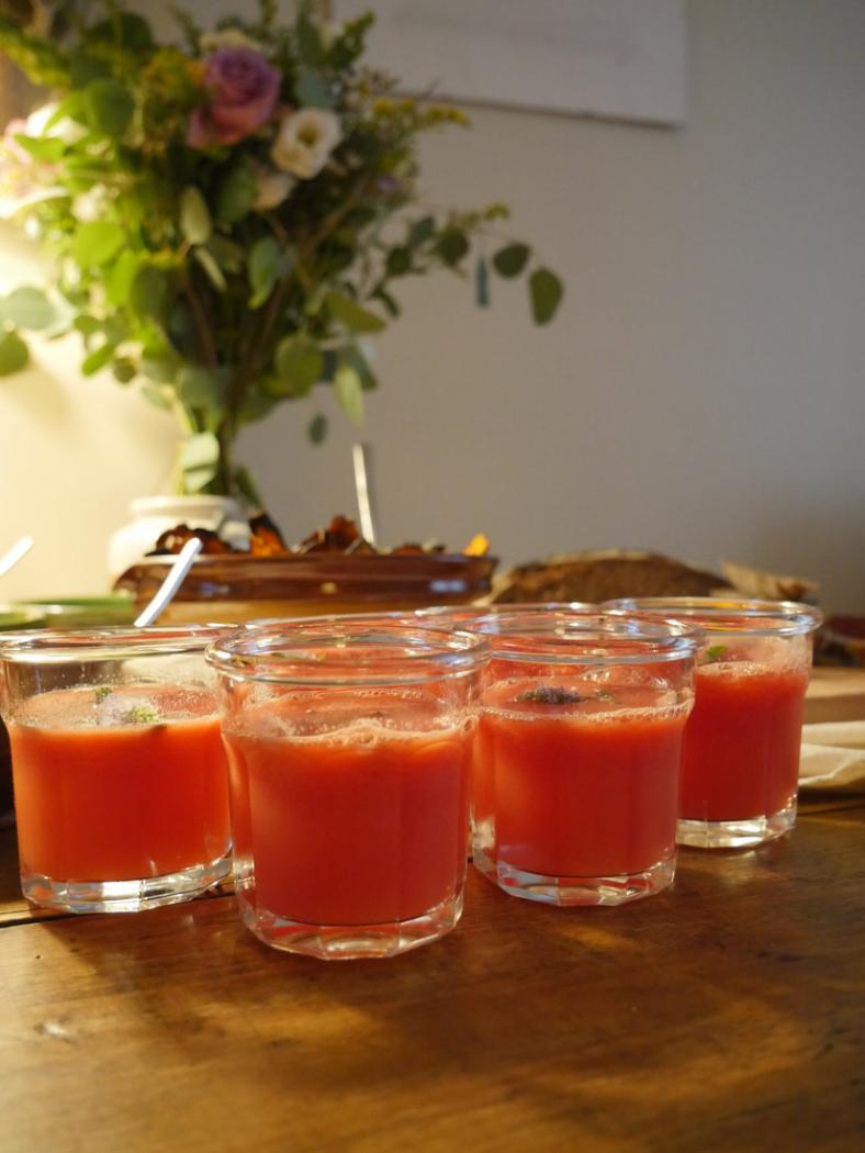Glasses of fresh vegetable juice with a bunch of flowers