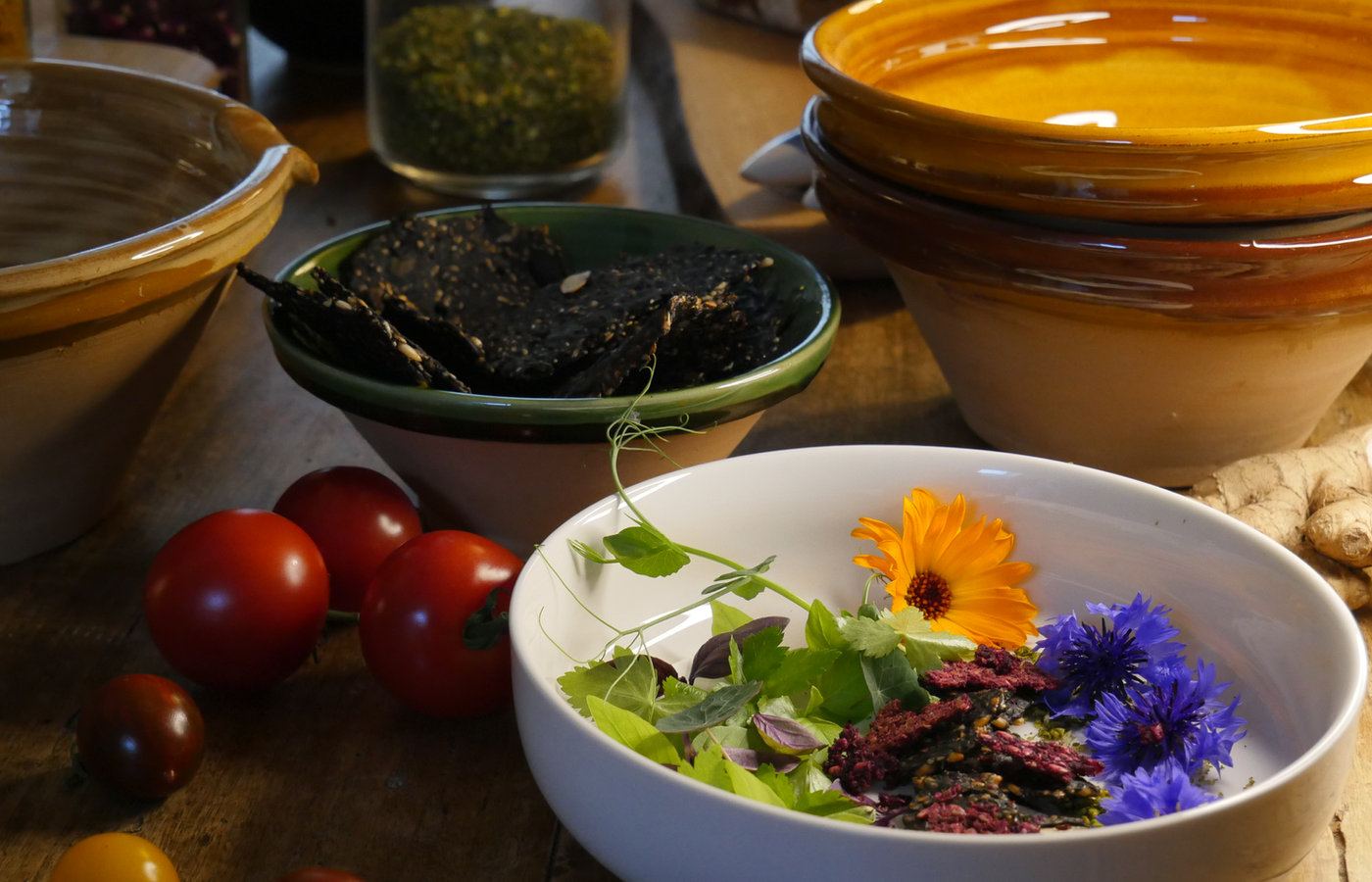 Seeded crackers, tomatoes and salad in ceramic bowls