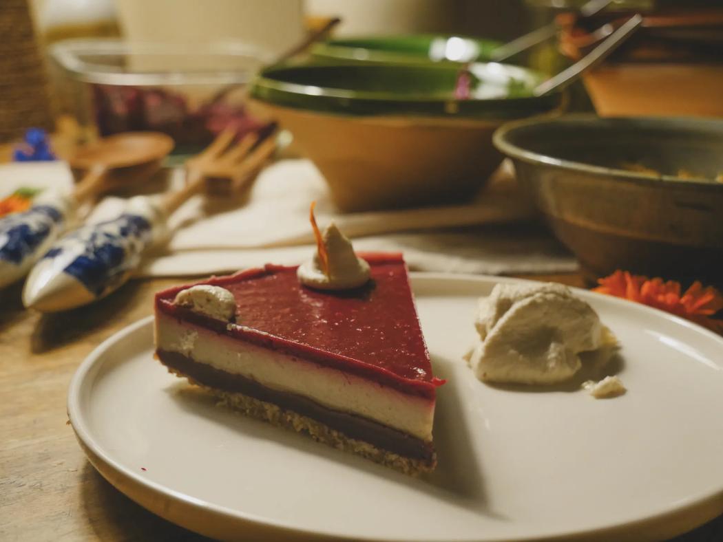 A slice of raspberry cake with cream