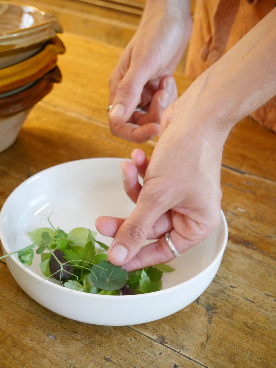Amandine finishing a dish with fresh herbs