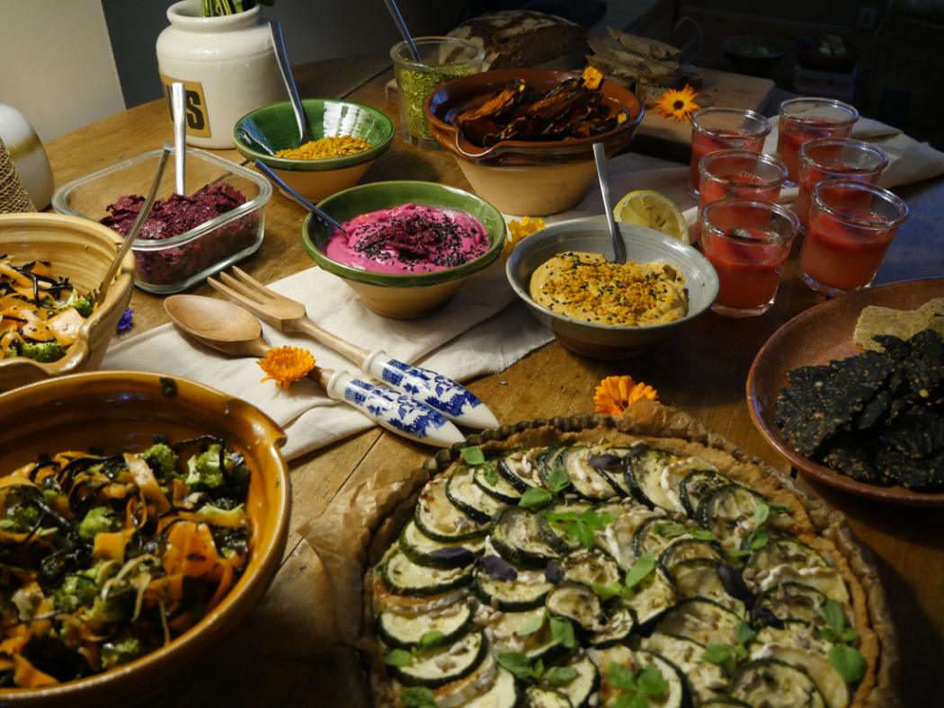 Shared retreat table with salads, tarts and juices